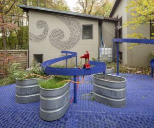 The rain yard sculpture a curving metal sculpture designed to capture rain that funnels rain into metal containers.